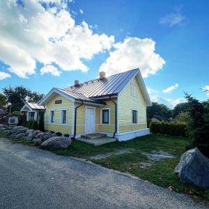 ein gelbes Haus mit einem Metalldach in der Unterkunft Klaukse in Aabla