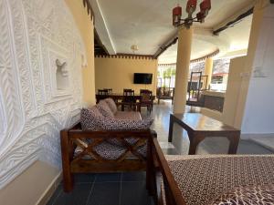 een woonkamer met 2 bedden en een tafel bij Charming and Remarkable 1 Bed Villa in Diani Beach in Diani Beach