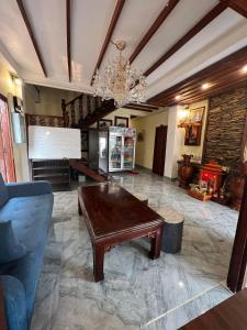 a living room with a wooden table and a chandelier at Chaluenxay Xiengthong Place in Luang Prabang