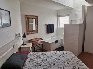 1 dormitorio con 1 cama y baño con lavamanos en Dwarskersbos,Skilliepark, en Velddrif