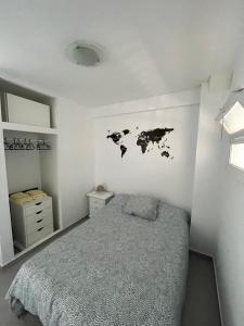 een slaapkamer met een bed en een kaart aan de muur bij Apartamento Los Cisnes in Benalmádena