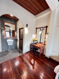 a room with a wooden table and a sink at Chaluenxay Xiengthong Place in Luang Prabang