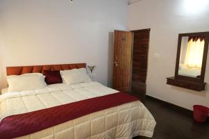 a bedroom with a large bed and a mirror at Greenhouse Homestay in Siddapur