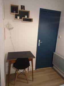 a room with a desk and a blue door at Appartement cosy au centre-ville de Toulouse in Toulouse