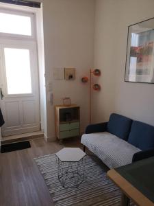 a living room with a blue couch and a table at Appartement cosy au centre-ville de Toulouse in Toulouse