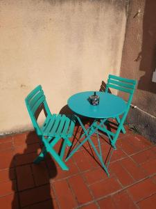 Appartement cosy au centre-ville de Toulouse في تولوز: كرسيين وطاولة عليها كوب