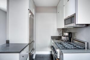 uma cozinha com um fogão e um micro-ondas em UES 3br penthouse w gym wd nr Central Park NYC-1110 em Nova York