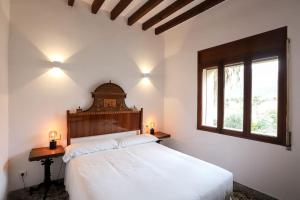 1 dormitorio con 1 cama, 1 mesa y 2 ventanas en Villa Ca'n Pipeta, casa mallorquina centro Soller, en Sóller