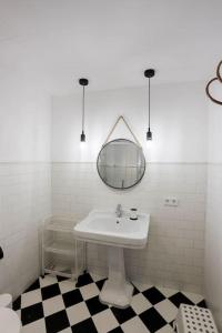 Baño blanco con lavabo y espejo en Villa Ca'n Pipeta, casa mallorquina centro Soller, en Sóller