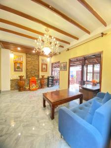Chaluenxay Xiengthong Place في لوانغ برابانغ: غرفة معيشة مع أريكة زرقاء وطاولة