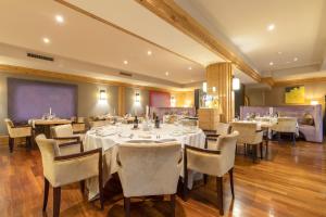 a dining room with tables and chairs in a restaurant at Hotel Royal in Crans-Montana