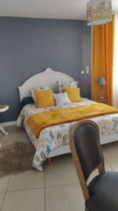 um quarto com uma cama e uma cadeira em Gîte aux trois suites parentales et son jacuzzi 