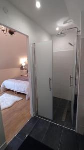 uma casa de banho com um chuveiro e um quarto com uma cama em Gîte aux trois suites parentales et son jacuzzi 