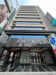 un edificio alto con escritura asiática en la parte delantera en Royal Fine Hotel en Kaohsiung