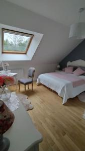 的住宿－Gîte aux trois suites parentales et son jacuzzi，一间卧室配有带粉红色枕头的床和窗户。