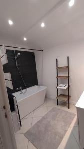 a bathroom with a tub and a shower and a sink at Gîte aux trois suites parentales et son jacuzzi 