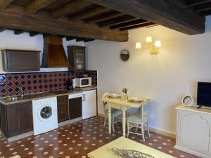 a kitchen with a table and a small table and a table and a microwave at Apartamentos Rurales El Zarzo in Hervás