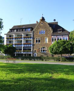 ein großes Backsteingebäude mit einem Park davor in der Unterkunft Hotel Klasen in Cochem