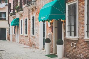 a brick building with a green umbrella on a street at Hotel Henry in Venice