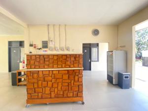a kitchen with a counter and a refrigerator at De Homestay Mitra RedDoorz Bitung in Bitung +29 photos