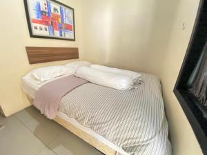 De Homestay Mitra RedDoorz Bitung tesisinde bir odada yatak veya yataklar