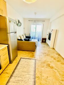 a kitchen with a refrigerator and a couch in a room at DARIVA apartment Nea Skioni in Nea Skioni +63 photos