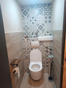 a small bathroom with a toilet and tiles at Chambre Les étoiles de Bevy in Molunes