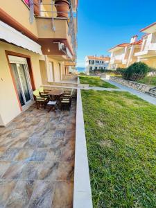 a patio with a table and benches in a building at DARIVA apartment Nea Skioni in Nea Skioni