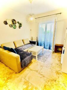 a living room with a yellow couch and a table at DARIVA apartment Nea Skioni in Nea Skioni