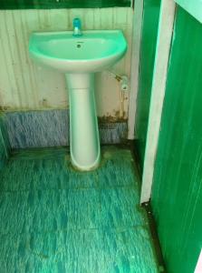 a bathroom with a white sink and a green floor at Hi Bengaluru in Bangalore