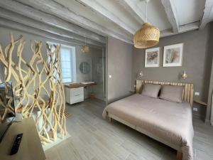 Schlafzimmer mit einem Bett mit einem Kopfteil aus Holz in der Unterkunft Gîte La Patouille in Amboise