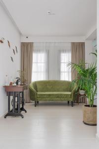 Petrou Suites في يوانينا: أريكة خضراء في غرفة المعيشة مع طاولة