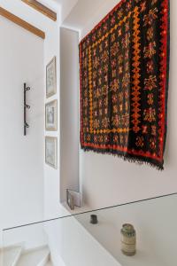 una alfombra colgada en una pared junto a una ventana en Petrou Suites en Ioánina