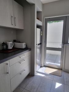 a kitchen with a door leading to a patio at The Sandy Golfer in Mount Maunganui