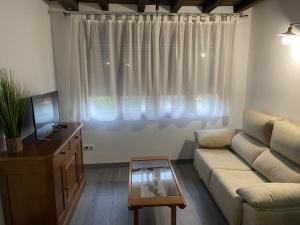a living room with a couch and a window at Apartamentos Rurales El Zarzo in Hervás