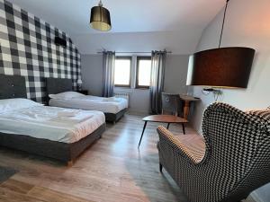 una habitación de hotel con 2 camas y una silla en Hotel-Przystań, en Kikół