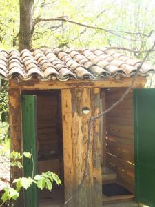 una casa exterior con techo de baldosa y puerta en Tente Tipi en pleine forêt, en Burzet