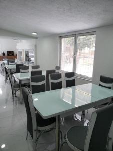 una sala de conferencias con mesas, sillas y ventanas en Hostel Bela en Ohrid