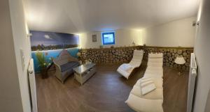 ein Wohnzimmer mit weißen Stühlen und einem Sofa in der Unterkunft Strandvilla Miramare in Boltenhagen