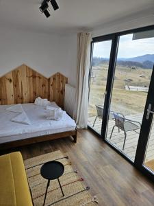 1 Schlafzimmer mit einem Bett und einem Balkon mit Aussicht in der Unterkunft Ursa Mica Glamping Resort in Şirnea