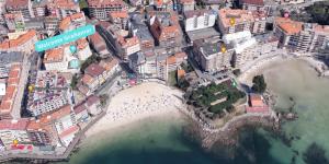 an aerial view of a city with a beach at Apartamento Welcome Grañamar in Sanxenxo