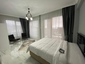um quarto com uma grande cama branca e janelas grandes em Villa منظر em Sapanca