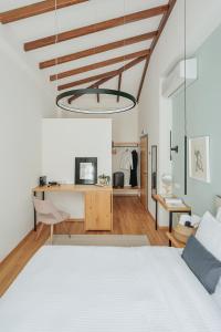 een slaapkamer met een wit bed en een bureau bij Petrou Suites in Ioannina