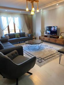 - un salon avec un canapé et une télévision dans l'établissement Luxury Apartments Trabzon, à Trabzon