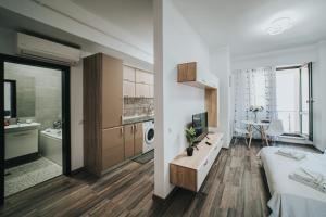 a bedroom with a bed and a bathroom with a sink at Urban Accommodation - Palas Mall Iasi in Iaşi