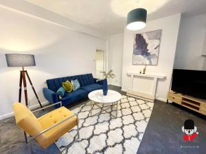 sala de estar con sofá azul y TV en KozyGuru / 2BR 3Beds / Beautiful Comfortable House / Worsley / Very Convenient Location / Close to local Amenities and Train Station / UMWO018 en Worsley