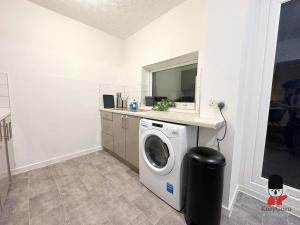 a laundry room with a washing machine and a counter at KozyGuru / 2BR 3Beds / Beautiful Comfortable House / Worsley / Very Convenient Location / Close to local Amenities and Train Station / UMWO018 in Worsley