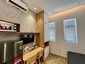 een kleine keuken met een bureau en een koelkast bij PANDORA HOUSE in Ho Chi Minh-stad