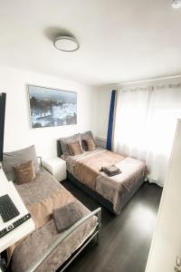 a bedroom with two beds and a desk with a laptop at Tau Design Hotel in Erlangen