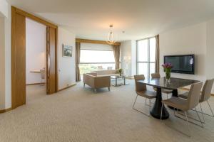 a living room with a table and chairs and a couch at Grand Hotel Ontur Cesme in Çeşme